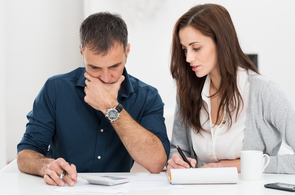 couple looking at car insurance policy to increase deductible