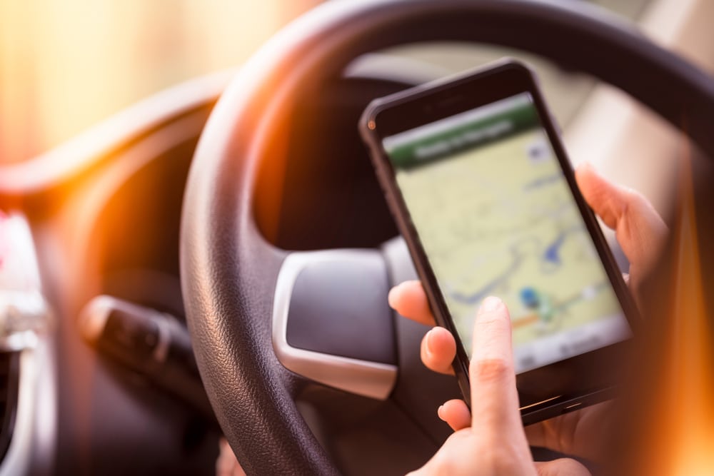 woman using gps on smartphone in drivers seat