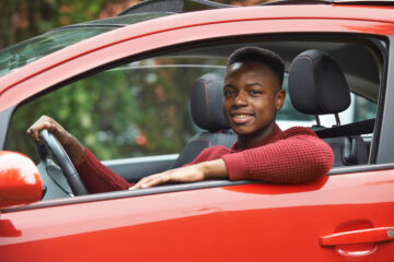 young african american driver in red car