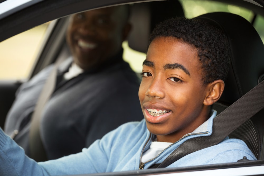 young driver in vehicle with father