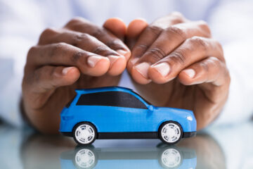 hands covering blue small car