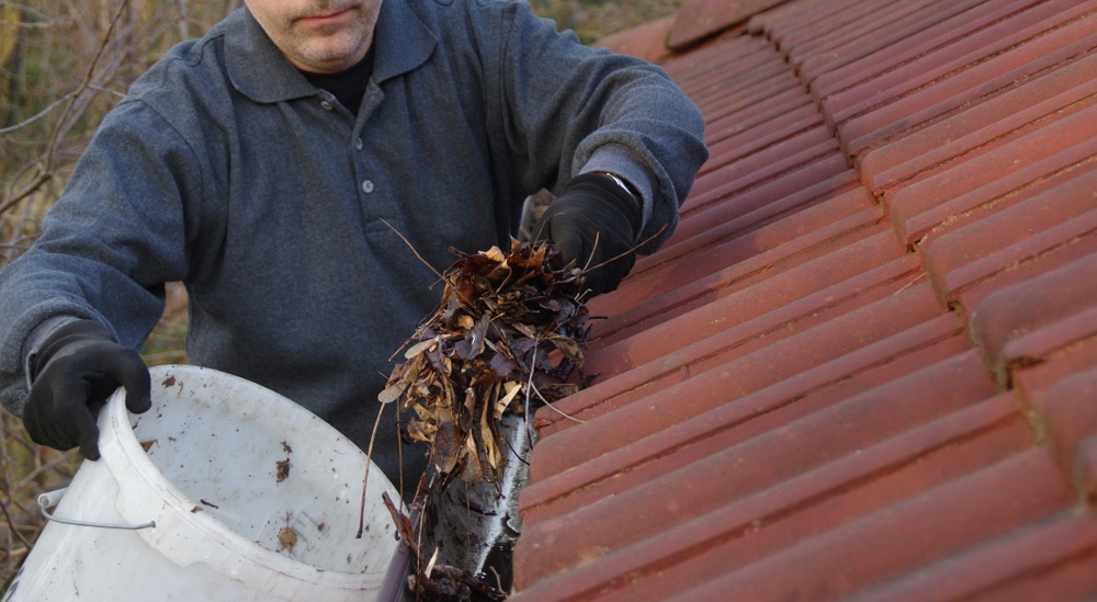 man cleaning gutters
