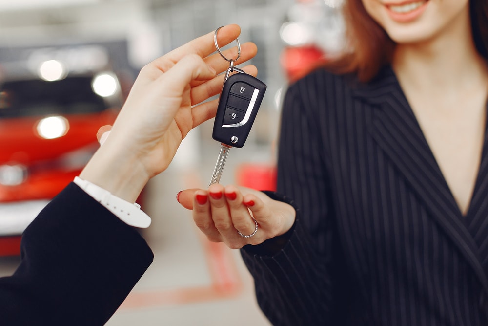 woman getting keys to a rental car