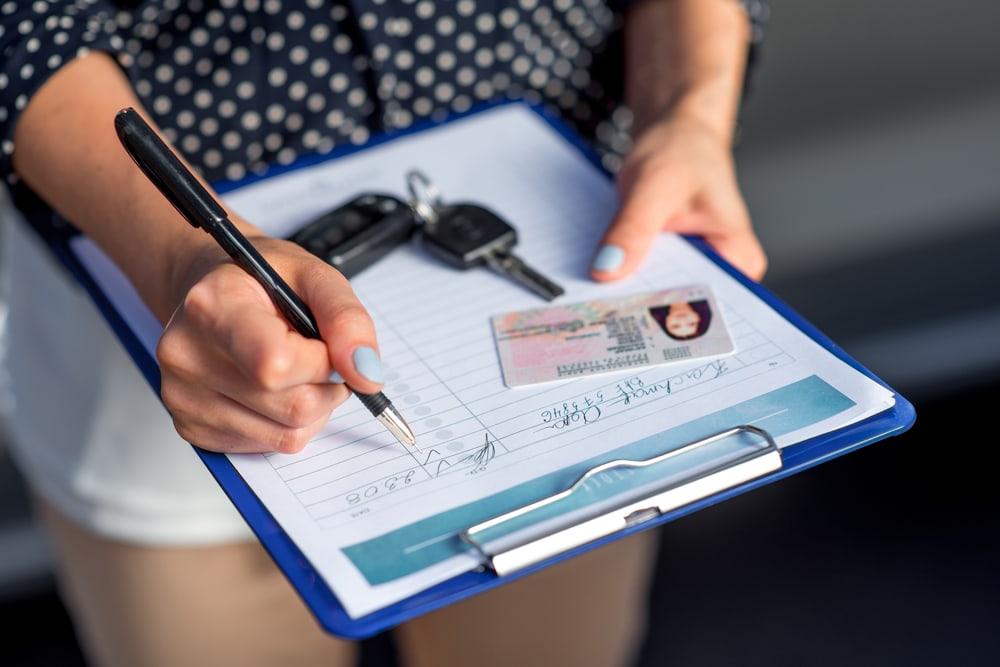 woman signing rental car agreement