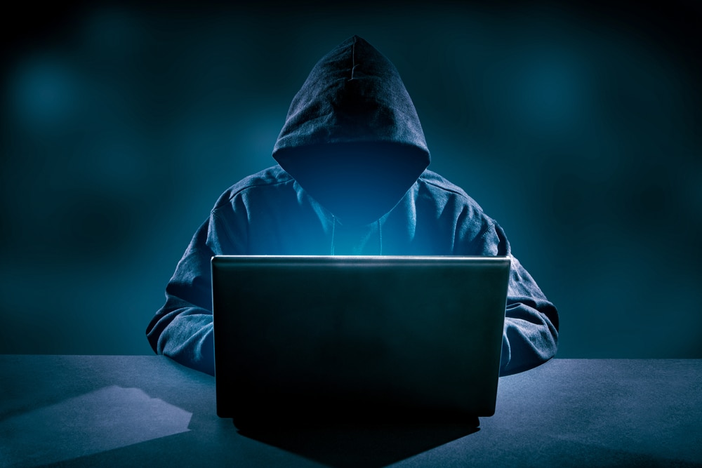 hacker on laptop with hoodie on