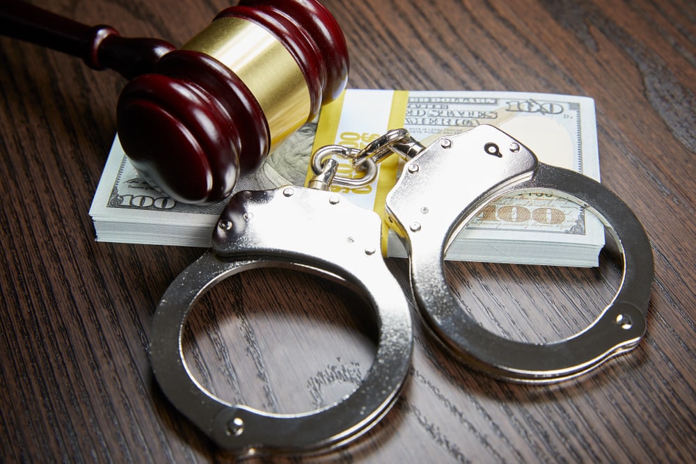 handcuffs by gavel and cash