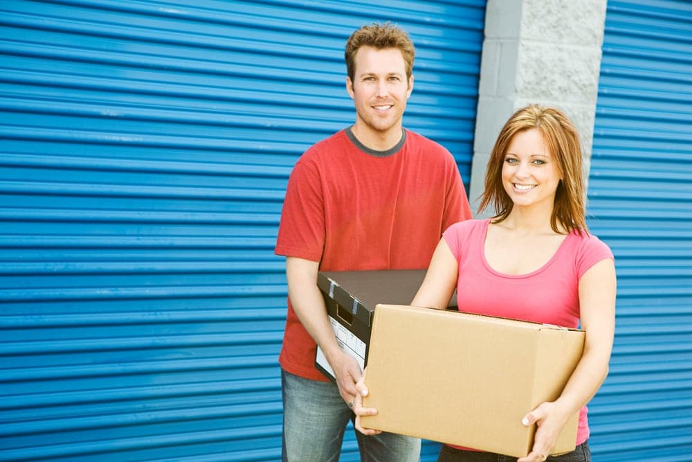 man and woman standing outside of storage unit with boxes