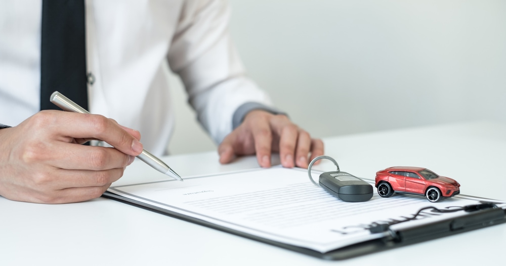 man writing on insurance policy document