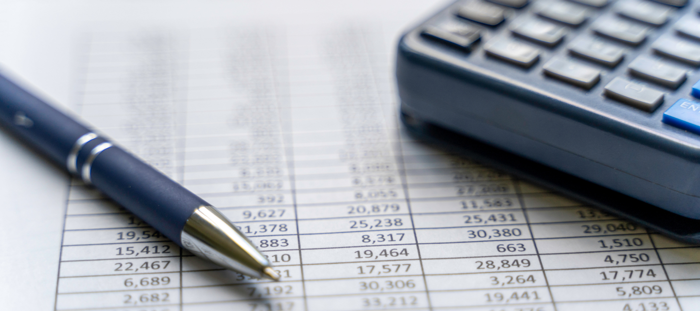 A pen and calculator on a spread sheet