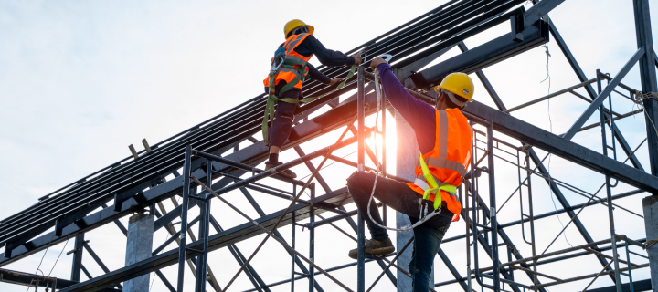 Construction workers climbing on a building frame.