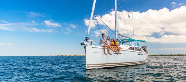 Sailboat in the ocean with a family sitting on the side